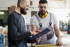 Hommes travaillant sur la découpe de panneaux MDF dans un atelier industriel